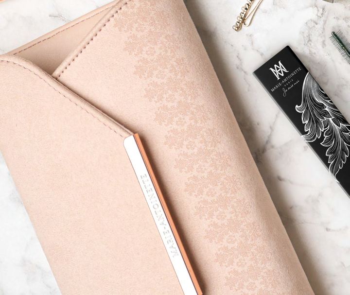 Blush-pink embossed clutch