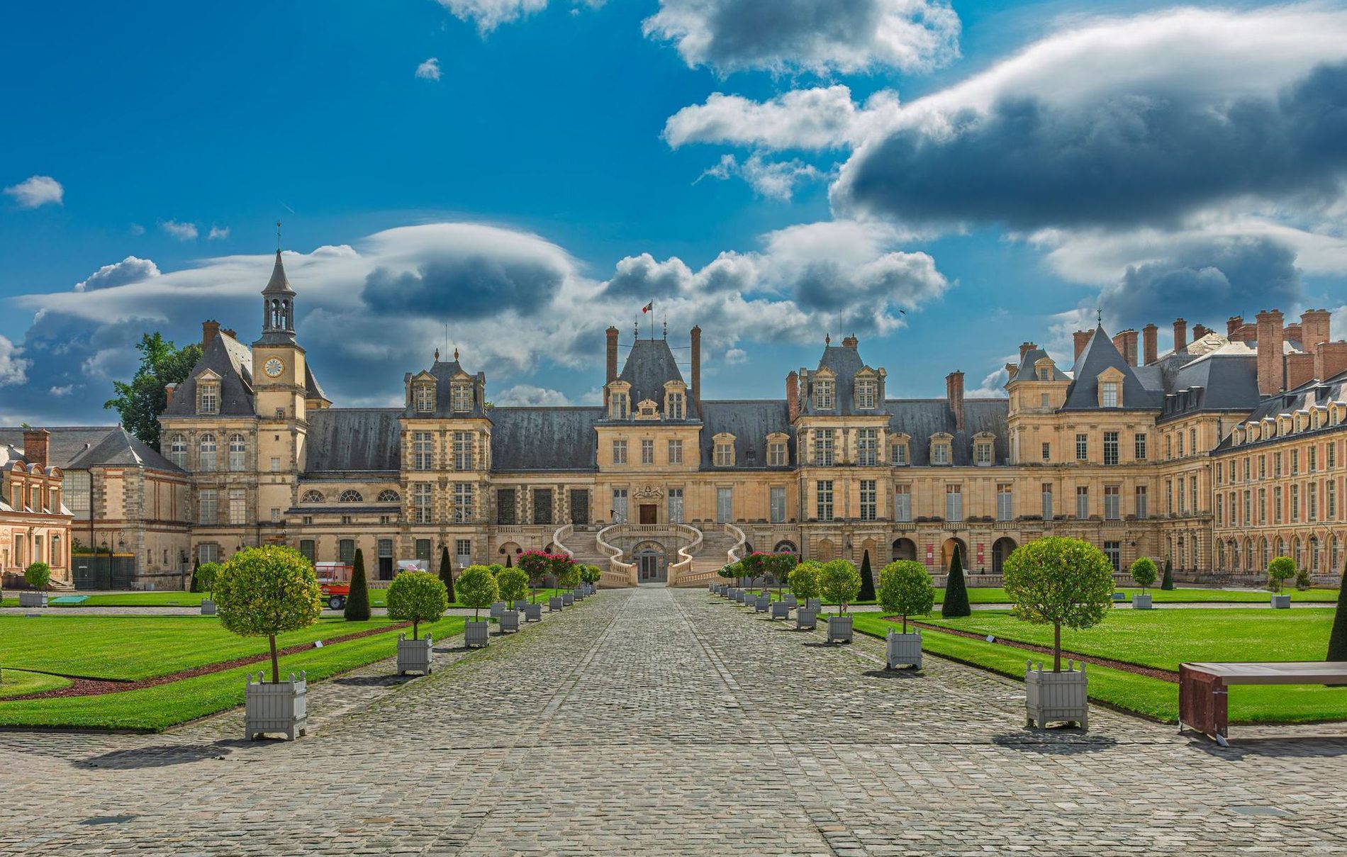 The Palace of Fontainebleau and its courtyard under a summer sky