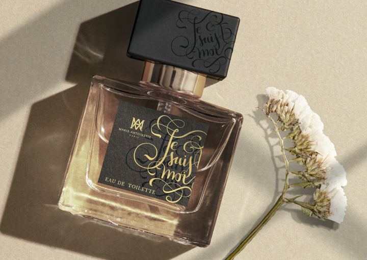 Perfume bottle beside dried flowers