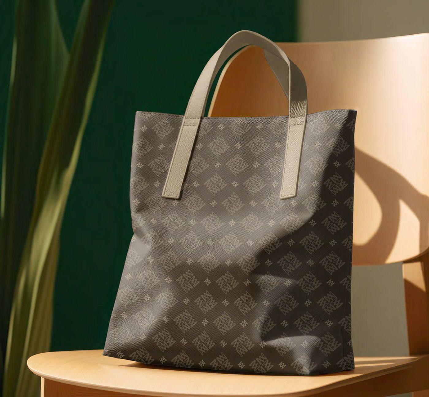 Ein Marie-Antoinette-Shopper mit Monogramm auf einem Stuhl vor einer tiefgrünen Wand